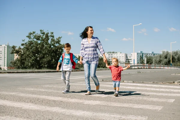 Mãe e seus filhos cruzando estrada a caminho da escola . — Fotografia de Stock