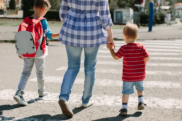 Madre e i suoi figli attraversano la strada per andare a scuola . — Foto Stock