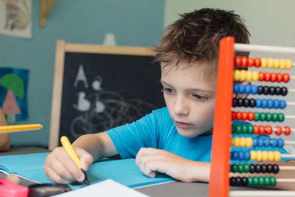 School boy working on math homework — Stock Photo, Image