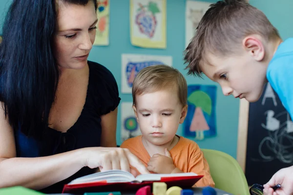 Madre educando a sus hijos en casa — Foto de Stock