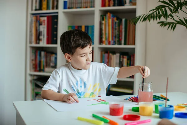 귀여운 소년이 수채화로 그림을 즐긴다 단지에 페인트를 사용하는 어린이가 — 스톡 사진