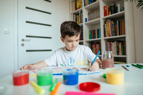 可爱的5岁学龄前男孩用左手画画 小孩用铅笔在纸上画画 — 图库照片