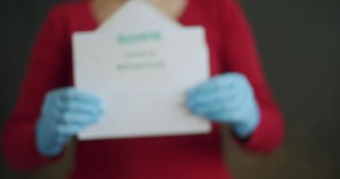 Covid-19 için kadın Negatif Antijen Algılama Testi. Yüzü Maskeli ve Mavi Eldivenli Tanımlanamayan Kişiye Zorla ve Negatif Coronavirüs Test Sonuçlarıyla Açık Zarfı Göster.