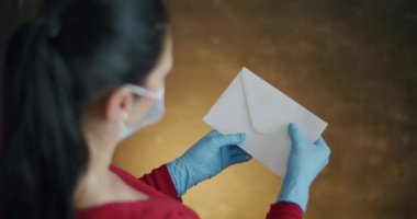Kadın Zarf Açma Sertifikası ile Pozitif Sonuçlar: Covid-19. Omzunda Cerrahi Eldiven Giyen Kadın Görünümü Zarfı Açma ve Pozitif Test Sonuçları Çıkarma Coronavirüs.