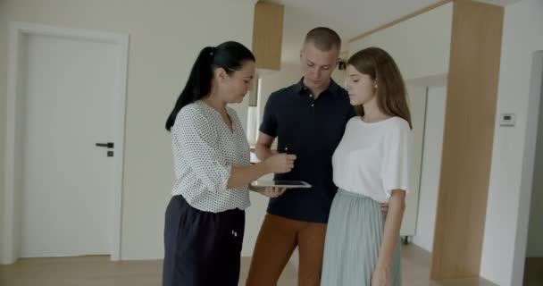 Agente Imobiliário Feminino Usando Tablet Digital Discutindo Com Jovem Homem — Vídeo de Stock