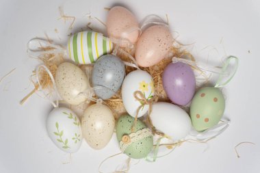 Renkli Paskalya yumurtaları kurutulmuş samanların üzerinde birlikte sergilenir. Her yumurta farklı bir tasarıma sahiptir. Bu sahne bahar ve bayram kutlamalarının ruhunu yansıtıyor..