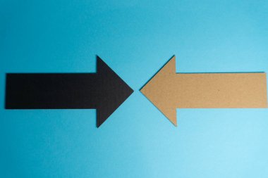 Mavi arka plana iki ok yerleştirildi. Siyah ok solu, kahverengi ok da sağı gösteriyor. Oklar farklı senaryolarda yön veya seçenekleri temsil ediyor..