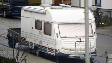 Karavan ve karavan caddeye park edilmiş. Tekerlekli karavan ve karavanla seyahat. Kamp tatilleri, açık hava park yerleri, macera yolculuğu, natürmort yaşam tarzı..