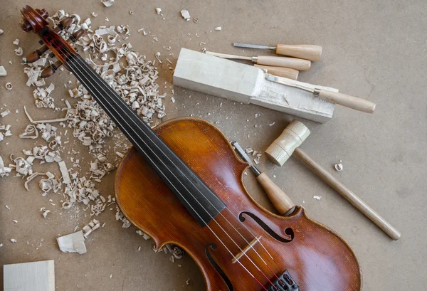 Red brown violin on luthiers desk. - Stock Image Stock Image