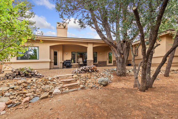 A residence features a sizable number of trees positioned in front of it, creating a verdant view that enhances the overall appeal of the property