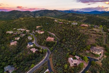 Sagecover arazi üzerinde renkli alacakaranlık, uzak meşe silueti ve yumuşak meşe ile sakin bir akşam sahnesi