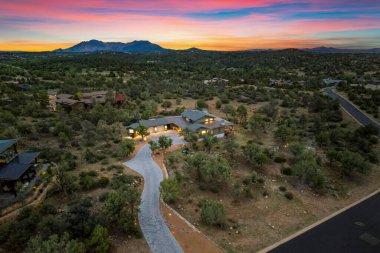 Yeşillik ve dağlarla çevrili güzel bir evin üzerinde nefes kesici bir gün batımı. Doğayla lüksün mükemmel bir karışımı..