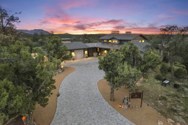 Yeşillik ve dağlarla çevrili güzel bir evin üzerinde nefes kesici bir gün batımı. Doğayla lüksün mükemmel bir karışımı..