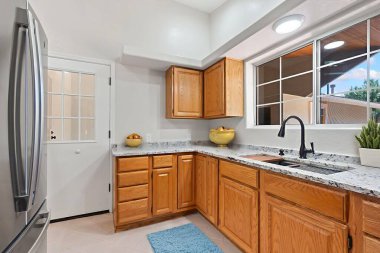 Mutfakta güzel ahşap dolaplar, çarpıcı granit tezgahlar, modern bir lavabo ve depolama ihtiyaçlarınız için geniş bir buzdolabı var.