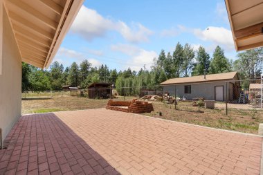 Güzel tasarlanmış tuğladan bir garaj yolu zarif bir şekilde büyüleyici bir eve açılıyor, dingin arka planda yemyeşil ağaçlarla çevrili.