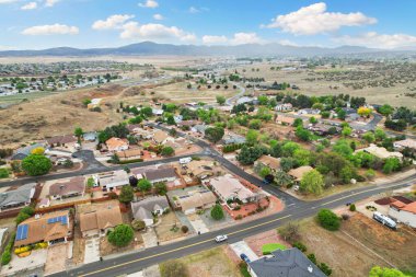 Geniş bir hava manzarası, arka planda zarif bir şekilde konumlanmış güzel bir golf sahası olan yerleşim alanını gösteriyor.
