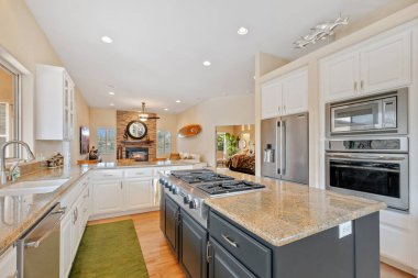 Burası modern paslanmaz çelik aletlerin zarif granit tezgahlarla eşleştirildiği, şık ve işlevsel bir yemek alanı sağlayan güzel bir mutfak.