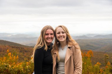 Dostlar neşeli anlar paylaşır, samimi arkadaşlar renkli yeşilliklerin ve manzaralı tepelerin tadını çıkarırlar.