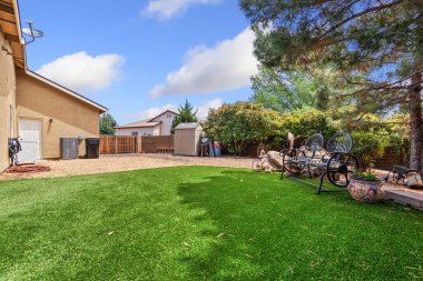 Rahatlamak ve rahatlamak için tavan vantilatörü ile tamamlanmış rahat sandalyeler ve bir masa içeren güzel bir teras.