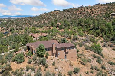 Geniş, geniş bir ev zarif bir şekilde güzel bir tepenin tepesine kurulmuş. Etrafı güzel ağaçlarla çevrili ve yeryüzündeki dağınık kayalarla çevrili.