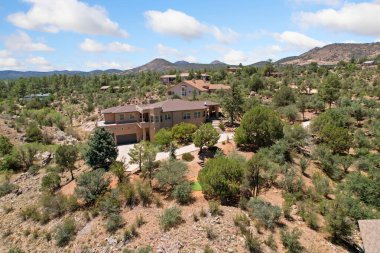 Geniş, geniş bir ev zarif bir şekilde güzel bir tepenin tepesine kurulmuş. Etrafı güzel ağaçlarla çevrili ve yeryüzündeki dağınık kayalarla çevrili.