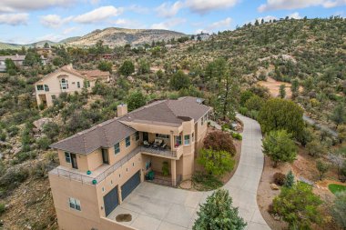 Geniş bir çöl manzarasının tam ortasında uzanan bir tepenin tepesinde ihtişamlı bir şekilde tünemiş tuhaf bir ev var.