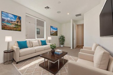 Oturma odasında rahat bir kanepe, şık sandalyeler, bir sehpa ve eğlence ve rahatlama için bir televizyon var.