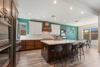 Zarif ahşap dolaplarla tamamlanmış modern paslanmaz çelik aletlerin yer aldığı çok güzel tasarlanmış bir mutfak.