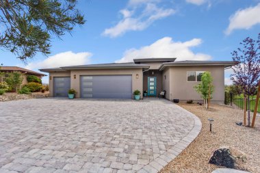 Bu güzel, mavi bir kapı ile tamamlanmış, iyi bakımlı tuğlalı bir garaj yolu olan büyüleyici bir ev.