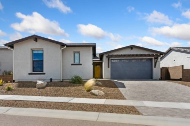 Çekiciliğini arttıran, sıcak ve misafirperver bir yer haline getiren davetkar sarı kapısı olan büyüleyici mavi ve beyaz bir ev.