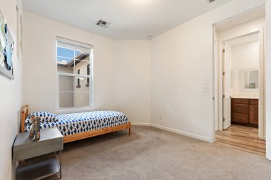 Konforlu bir yatak odası. Tek kişilik bir yatak odası ve doğal ışık alan mütevazı bir pencere. Hoş bir atmosfer yaratıyor.