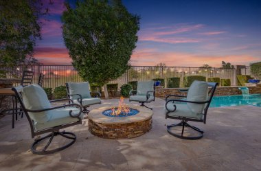 Avlunun ortasında toplanma için mükemmel bir şekilde yerleştirilmiş rahat sandalyelerle çevrili rahat bir ateş çukuru var.