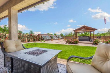 Rahat sandalyeler ve serin meltemler için bir tavan vantilatörü eşliğinde iyi yerleştirilmiş bir masa sunan enfes bir veranda.