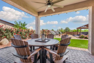 Rahat sandalyeler ve serin meltemler için bir tavan vantilatörü eşliğinde iyi yerleştirilmiş bir masa sunan enfes bir veranda.