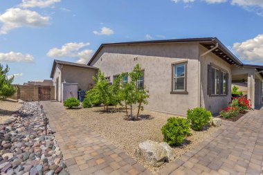 Geniş bir arazide bulunan büyüleyici bir ev. Evin ön girişine davetkar bir şekilde giden çakıllı bir patika var.