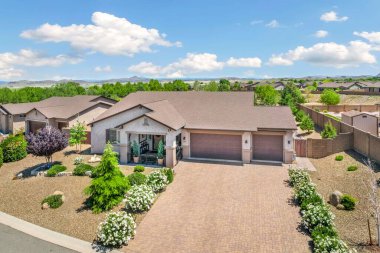 Önünde güzel bir sundurma ve canlı çiçekler olan büyüleyici bir ev manzaraya güzellik katıyor.