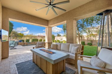 Terasta sıcak bir ateş çukuru, rahat bir kanepe, birkaç sandalye ve hatta sizi sıcak günlerde serin tutacak bir tavan vantilatörü var.