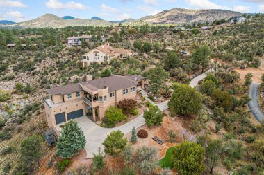 Geniş bir çöl manzarasının tam ortasında uzanan bir tepenin tepesinde ihtişamlı bir şekilde tünemiş tuhaf bir ev var.