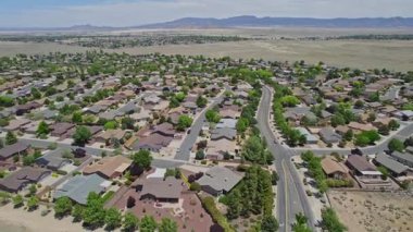 Geniş bir garaj yolu olan güzel bir ev ve önünde zarif bir şekilde duran birkaç ağaç, doğal gölgeler sunuyor ve manzarayı güzelleştiriyor.