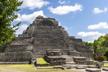 Yıpranmış taş basamaklar renkli bulutlu gökyüzünün altındaki eski piramidin zirvesine doğru yükseliyor.