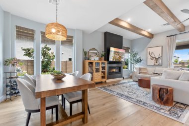 Burası şık, ahşap bir masa ve sıcak bir ortam yaratan zarif sandalyeler ve şömine eşliğinde çok güzel bir oturma odası.