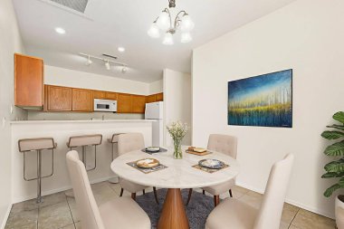 Yemek odasında güzel düzenlenmiş yuvarlak bir masa ve birkaç sandalye var. Mutfak alanına sorunsuz bir şekilde bağlanıyor.