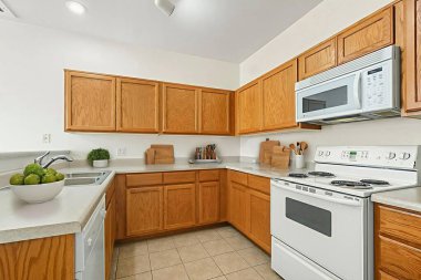 Mutfakta güzel ahşap dolaplar, parlak beyaz bir soba, uygun bir mikrodalga fırın ve günlük işler için işlevsel bir lavabo bulunuyor.