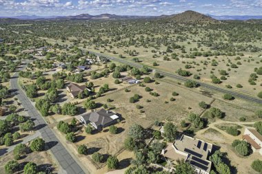 Arkaplanda dağınık ağaçlar ve parlak mavi bir gökyüzünün olduğu geniş ve geniş bir alan.