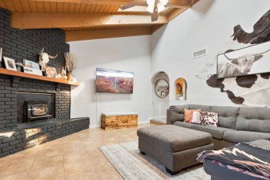 Hoş bir şöminesi ve şık bir masası olan rahat bir oturma odası. Rahatlamak ve çalışmak için sıcak ve davetkar bir ortam yaratıyor.