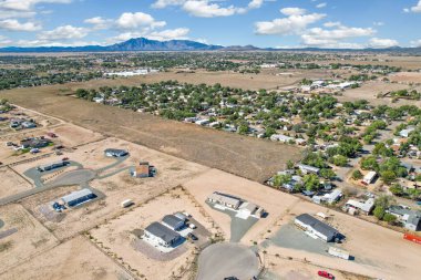 Uçsuz bucaksız bir toprak arazinin ortasında iki garaj kapısı olan bir ev var.