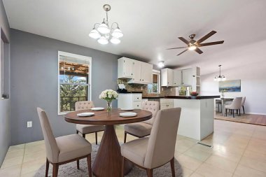 Konforlu bir evde, bir kaç rahat sandalyeyle çevrili güzel bir yemek odası var.