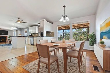 Konforlu bir evde, bir kaç rahat sandalyeyle çevrili güzel bir yemek odası var.