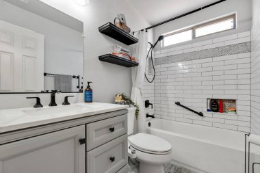 Çağdaş bir dokunuş için şık bir renk paleti ve fonksiyonel raf içeren güzel tasarlanmış modern bir banyo keşfedin..