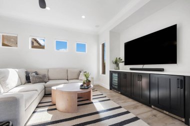 Rahat bir kanepe, şık bir masa ve boş zamanlarınızda eğlenmek için geniş bir televizyon olan rahat bir oturma odası.